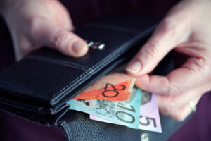 Adult Woman Female Hand Pulling Out Australian Money From A Leather Wallet.
